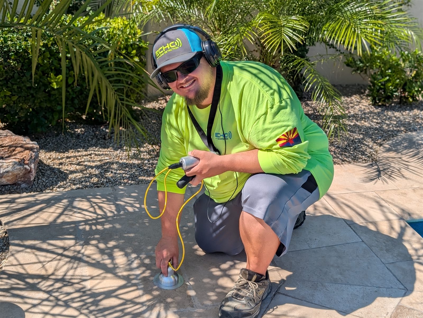 Echo technician using acoustic listening equipment to locate a pool leak