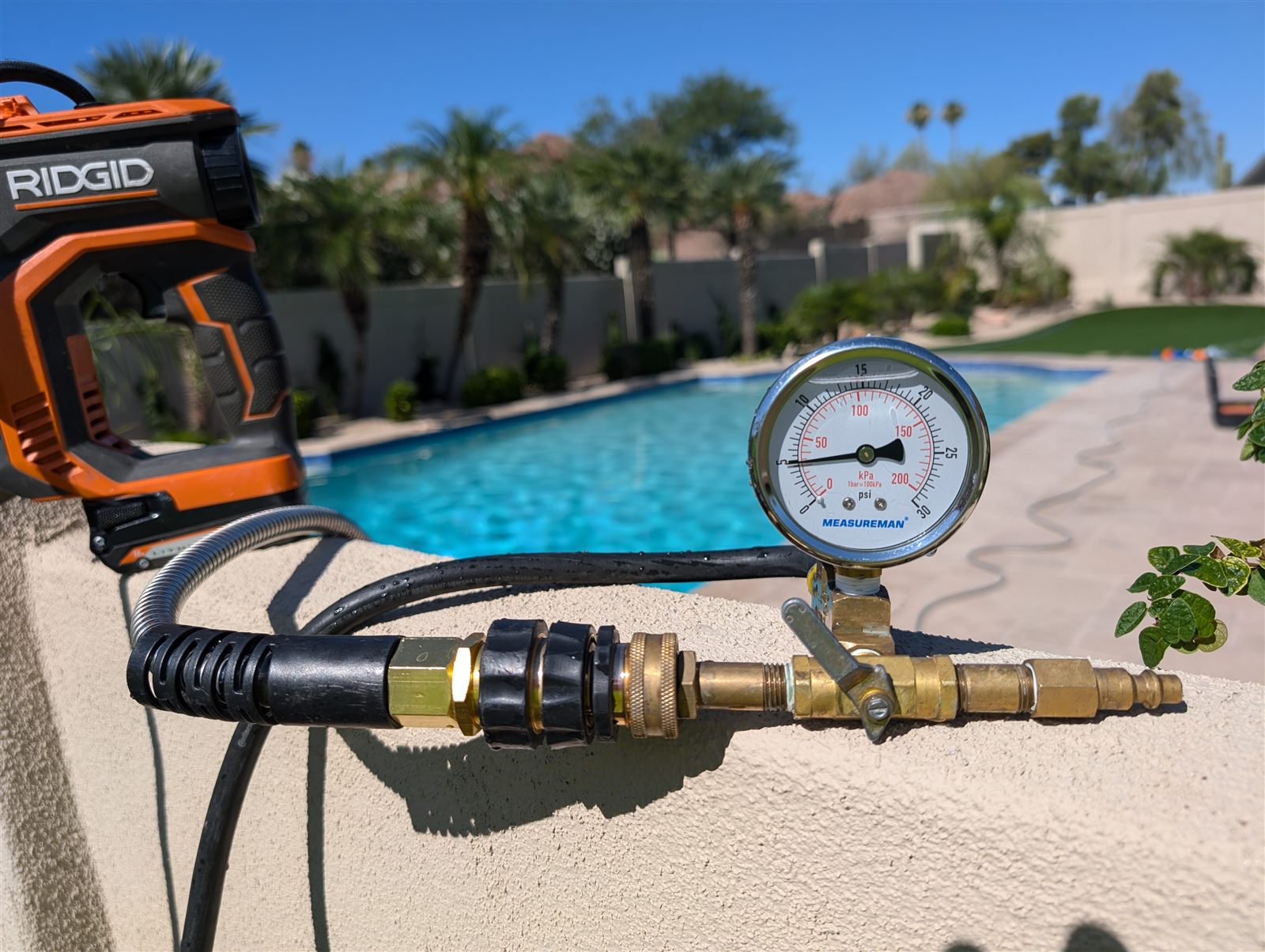 Pool plumbing pressure gauge beside a Phoenix-area swimming pool